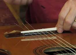 قبل از چسباندن ، خرک جدید را روی محل قرار دهید و مطمئن شوید به خوبی در جای خود مینشیند و انطباق درستی با سطح گیتار دارد.